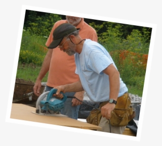 A Volunteer Uses A Circular Saw To Cut A Board On A - Backpack #8305772 A Volunteer Uses A Circular Saw To Cut A Board On A - Backpack #8305772